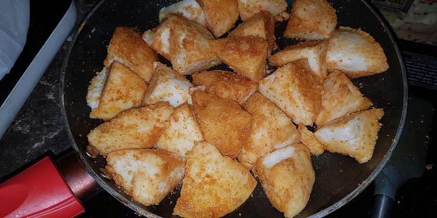 Steamed idlis coated with spicy podi, a flavorful delight.