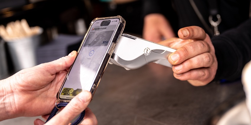 A person opting for digital transaction through a phone and the billing machine