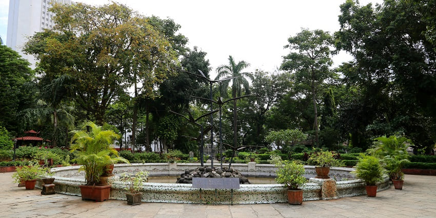 Lush greenery, serene pathways, vibrant flora, and peaceful ambience for visitors.