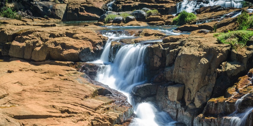 Puliyancholai falls tumbling over rocks artistically is a scenic attraction in Trichy