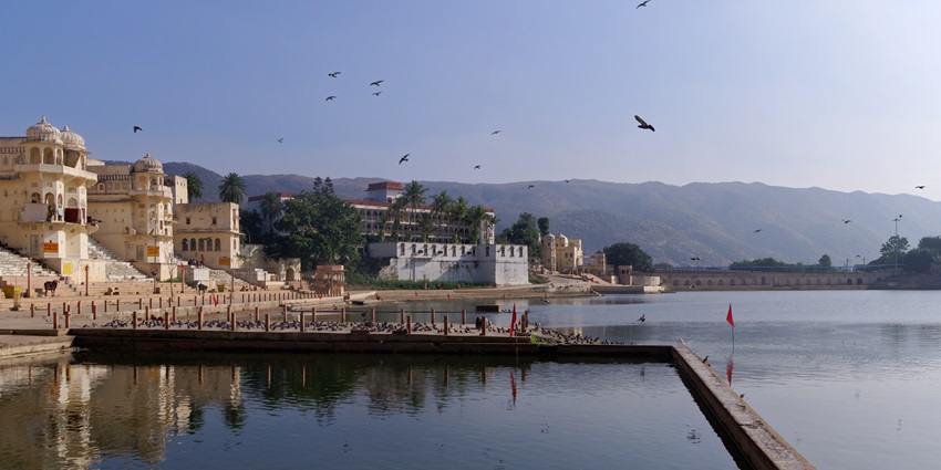 Calm lake view of Pushkar Lake with devotees on the ghats doing puja.
