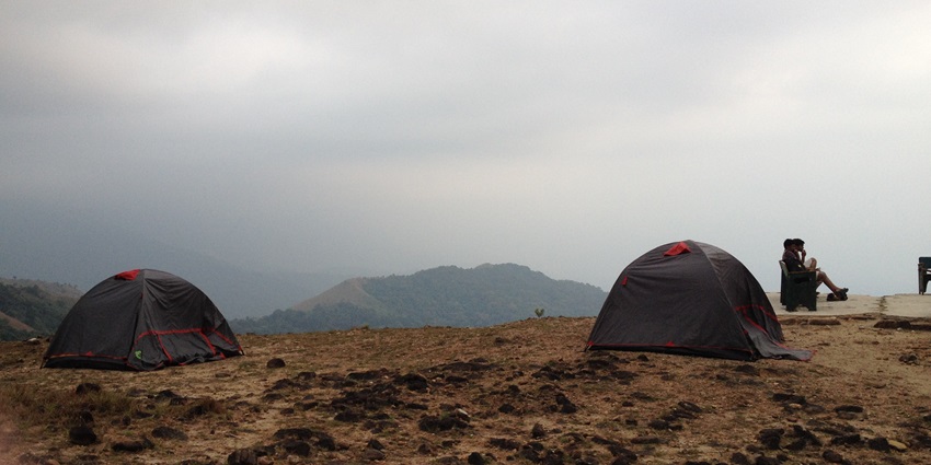 Image of tents in Pushpagiri Wildlife Sanctuary with stunning view of hills covered in lush greenery