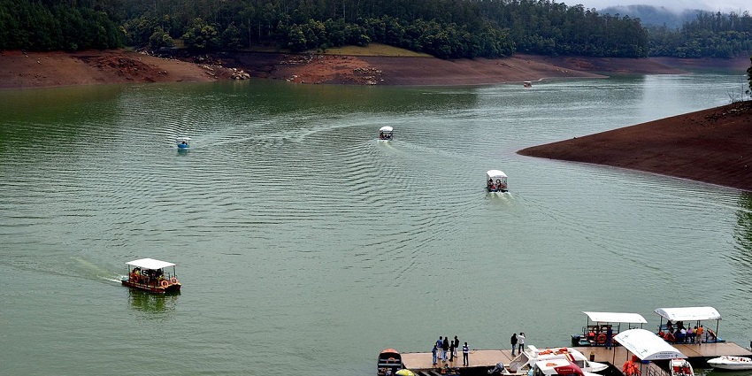 Boating in Pykara Lake, with green hills and clear skies in the background