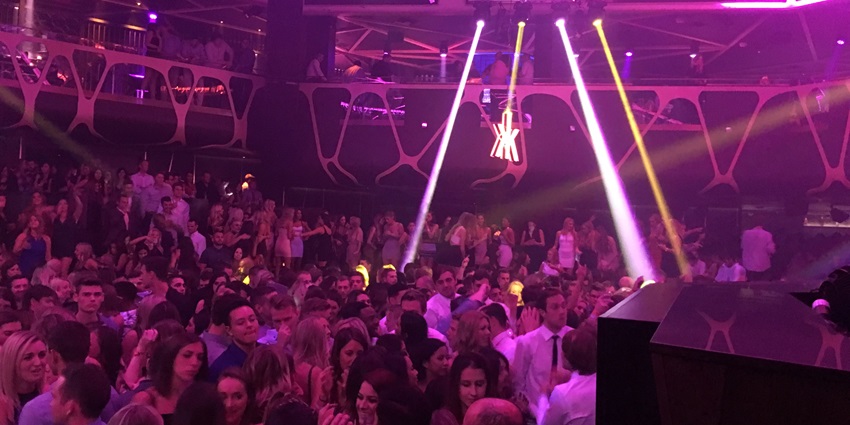View of Neon lights and people dancing to the DJ music