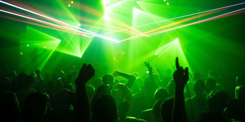People enjoying a vibrant techno party in Quake Arena late at night