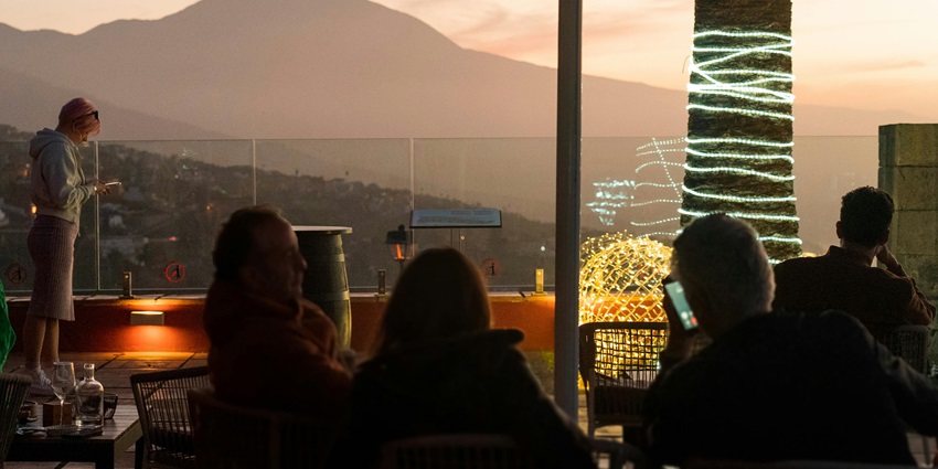 A picture of a rooftop bar in Phuket with scenic views of the town at night