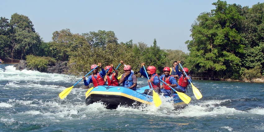 A picture of a group of tourists enjoying rafting in a tranquil river with a steady stream
