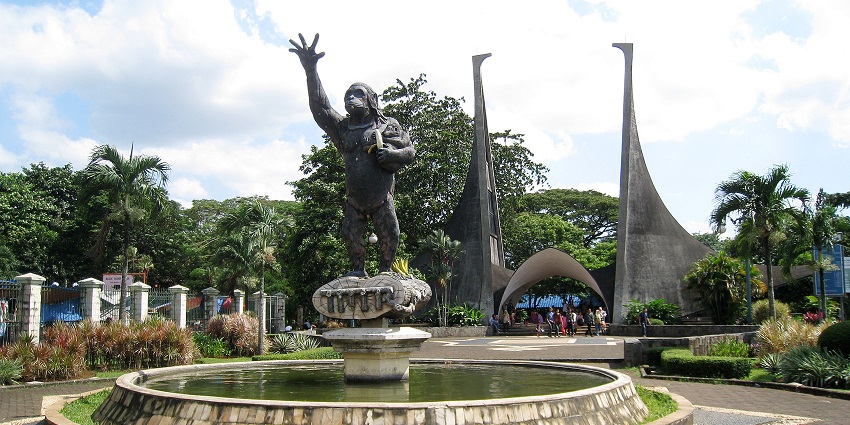 The entrance gate of Ragunan Zoo, featuring a statue in the middle with intricate designs.