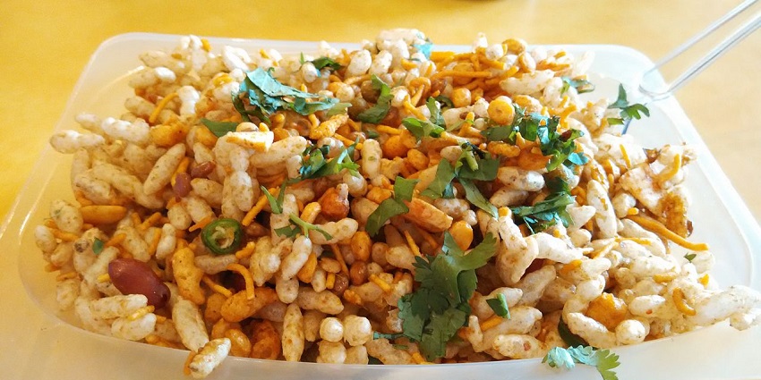 Bhelpuri, an Indian chaat made of puffed rice, garnished with cilantro, sev, and chilli.