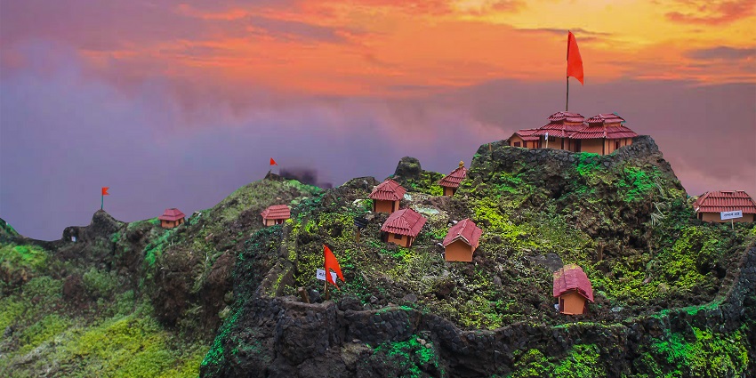 Aerial view of the Rajgad fort surrounded by lush greenery with sunset hues