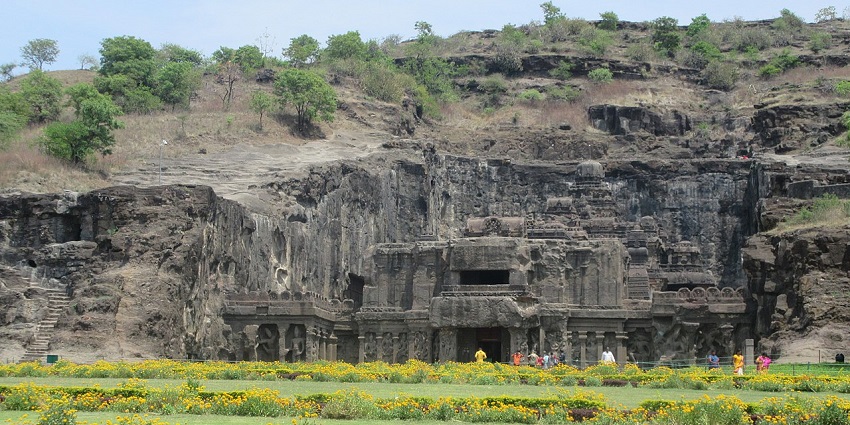 Ancient rock-cut caves in Maharashtra, surrounded by rugged terrain and natural greenery.