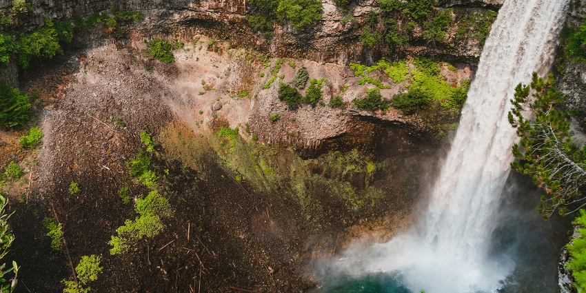 An aerial view of a scenic waterfall which is a place to visit near Sighanpur Caves.
