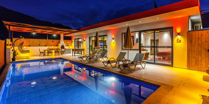 View of a luxurious pool in a hotel illuminated by exotic lights at twilight