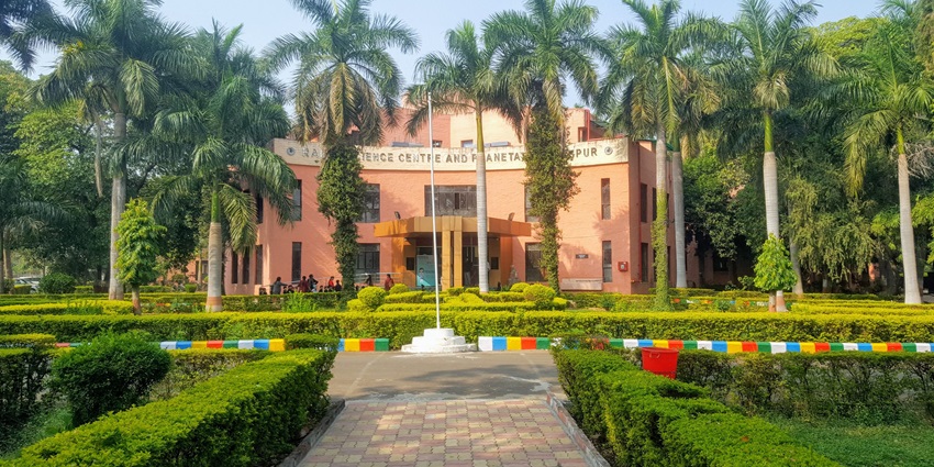 Image of the Raman Science Centre surrounded by the lush trees and the beautiful garden