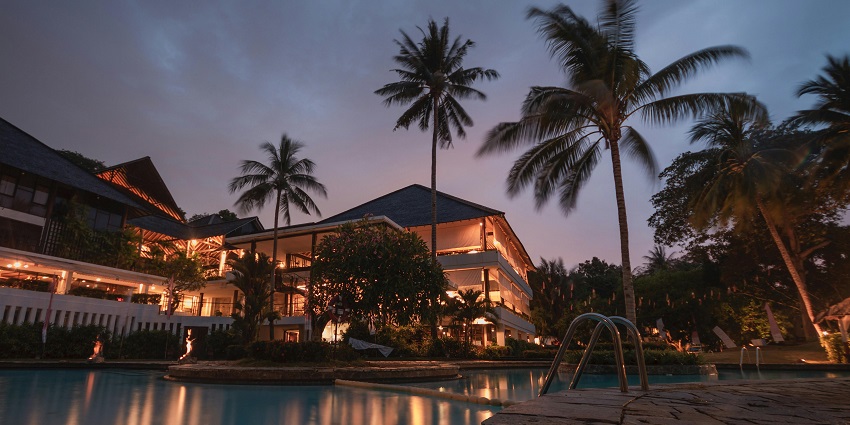 A serene shot of a resort with a pool captured during the evening.
