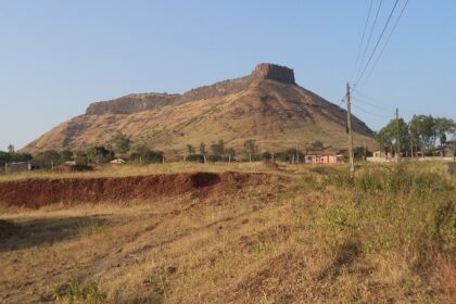 View of Ramshej Fort with rocky terrain and scattered greenery in Nashik, Maharashtra.