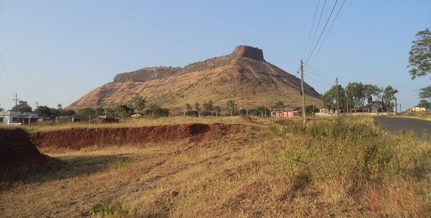 View of Ramshej Fort with rocky terrain and scattered greenery in Nashik, Maharashtra.