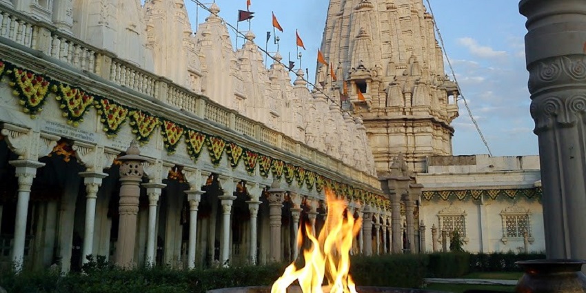 Performing Aarti at Rani Sati Temple with vibrant rituals inside the temple complex.