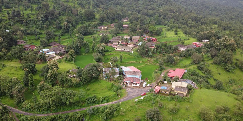 A panoramic view of a village in Ratnagiri, showcasing its hills during the rainy season.