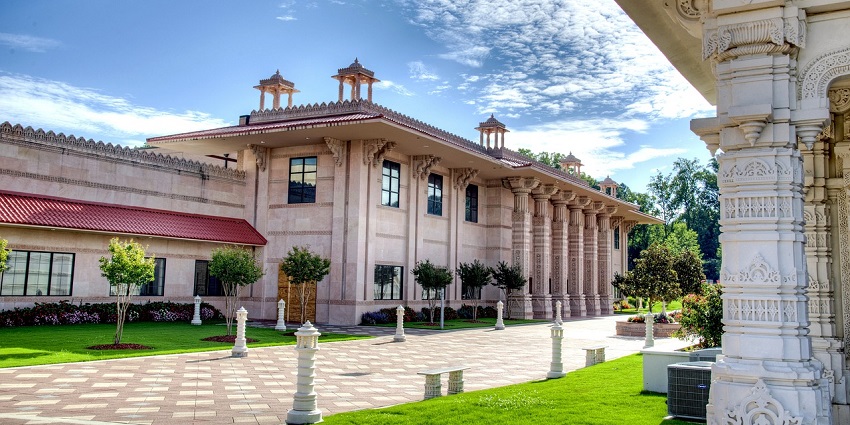 A panoramic view of a large, ornate Hindu temple complex under a clear blue sky.