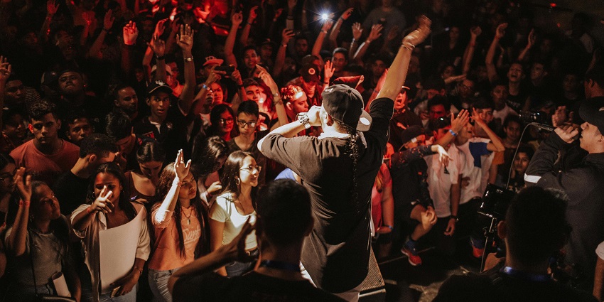A colorful decor out in the open and a man performing on the stage