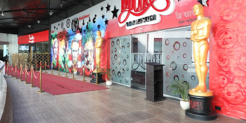 A vibrant red carpet leading into a wax museum, showcasing lifelike figures