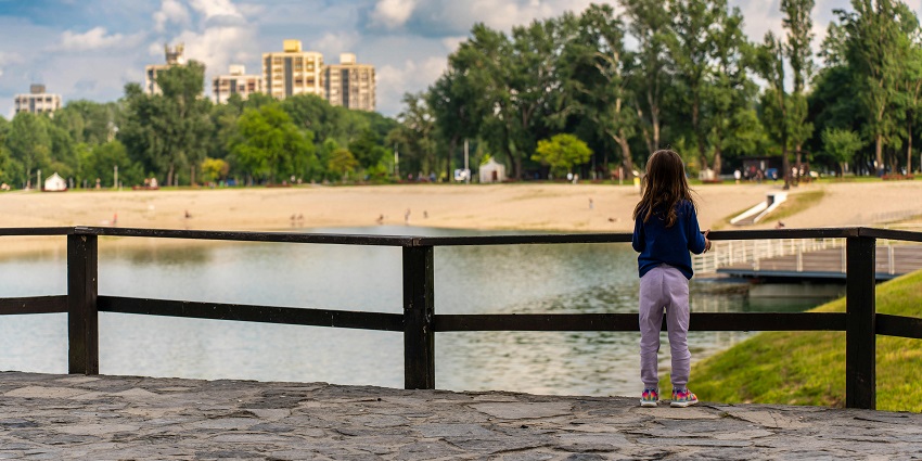 Enchanting back view of a girl on a bridge, soaking in the serenity of nature!