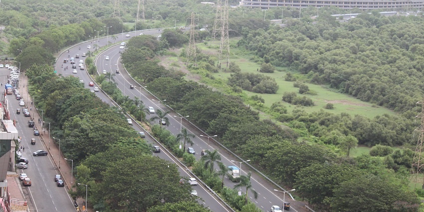 Scenic view of Palm Beach Road with the coastline on one side and city skyline on the other
