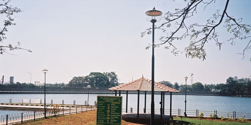 A tranquil view of Sankey Tank, featuring lush greenery and calm waters