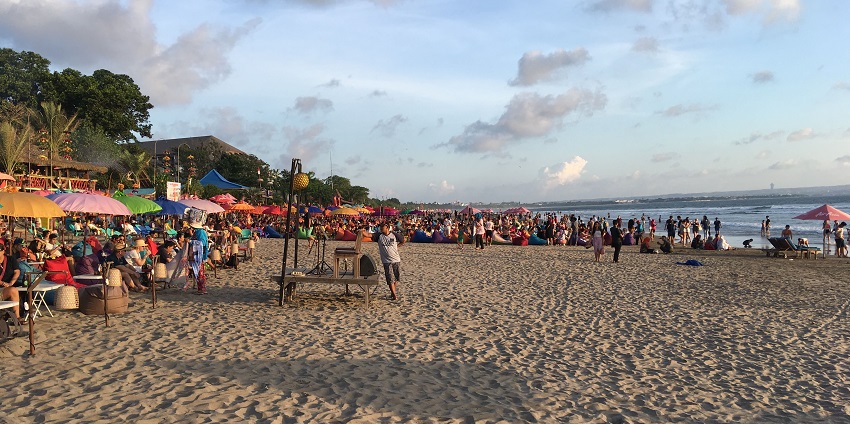 The sands and the sea of the Seminyak Beach with some tourists.
