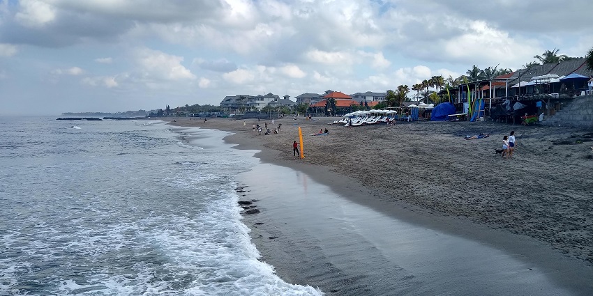 People relaxing and walking at the beach, one of the top things to do in Canggu.
