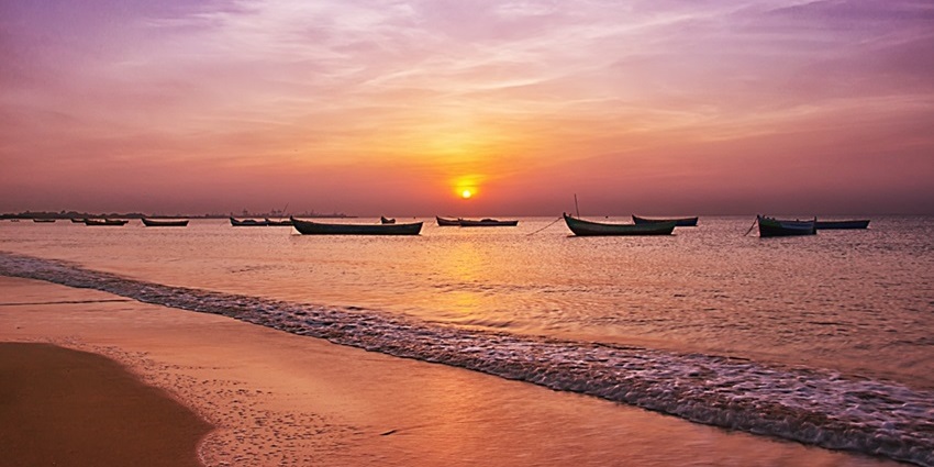 A stunning sunset at Thoothukudi Harbour Beach featuring shimmering blue waters.