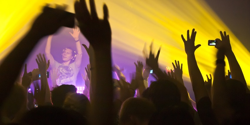 Partygoers enjoying a rave party in Bangkok, surrounded by pulsing lights and music.