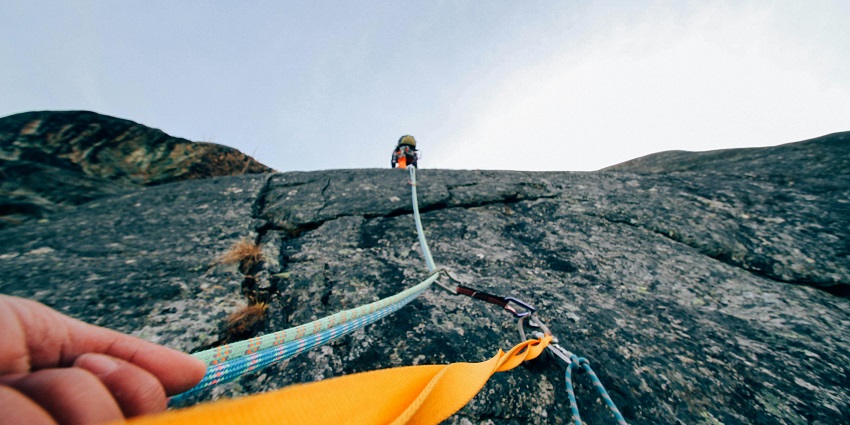 An image of adventurers engaging in rock climbing on a natural rock formation in Matheran.