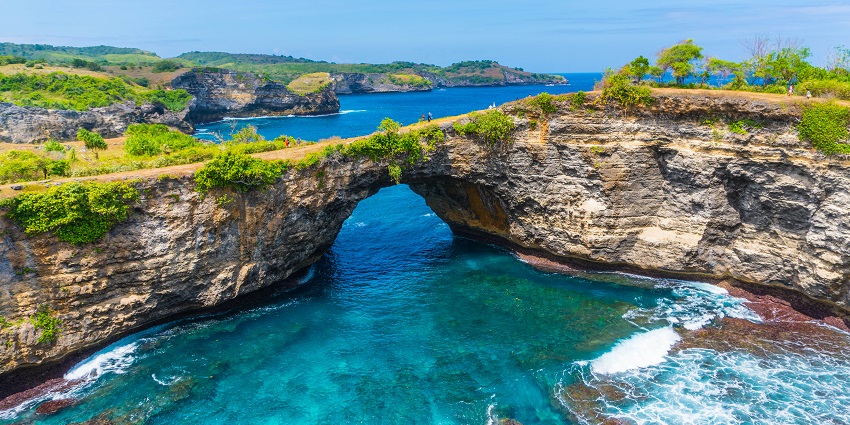 A natural bridge on the clear blue waters of Nusa Penida Island, a part of Indonesia.