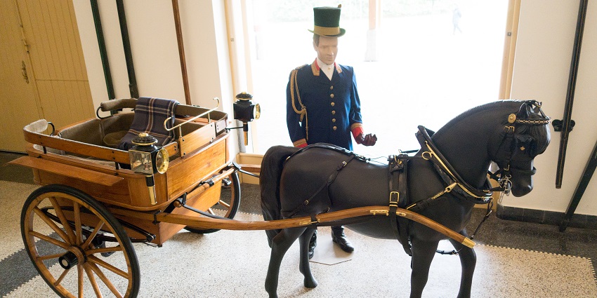 Ornate royal cart on display with a statue for a ride experience