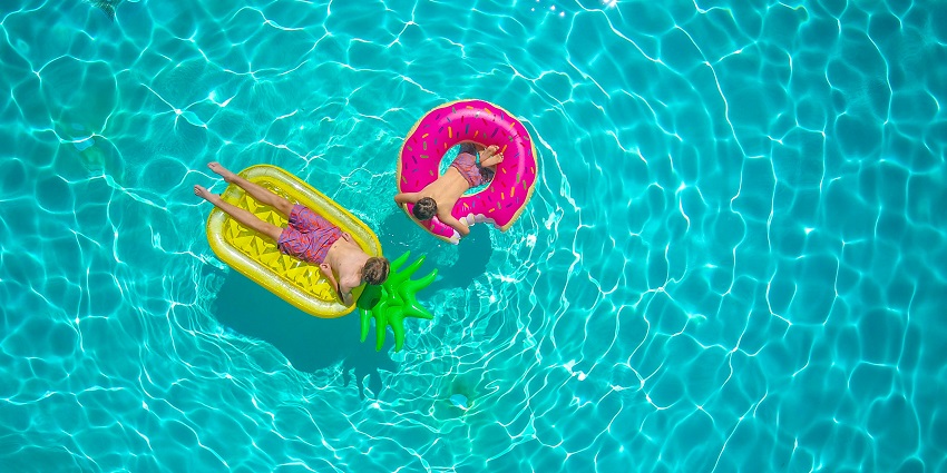A view of two boys happily splashing in a pool, enjoying a fun swim in a waterpark.