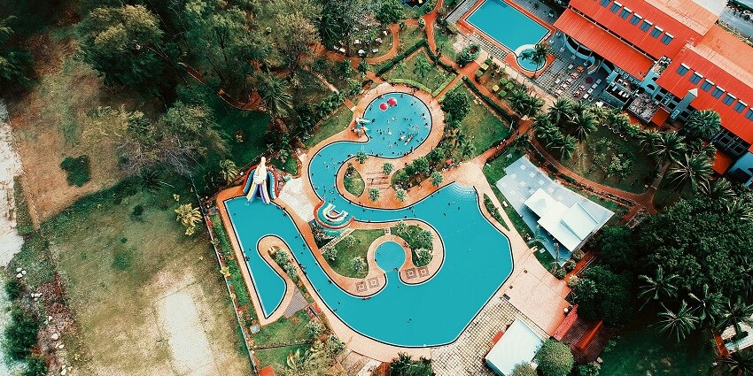 An aerial view of Saina Resort featuring a rectangular swimming pool surrounded by lounge chairs.