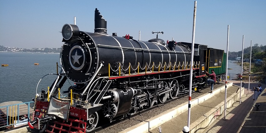 A picture of a life-size train model at a picnic place in Bhopal, with a lake flowing adjacent to it