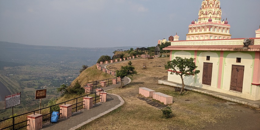 Scenic view of Sajjangad Fort set against the backdrop of the Sahyadri mountains.