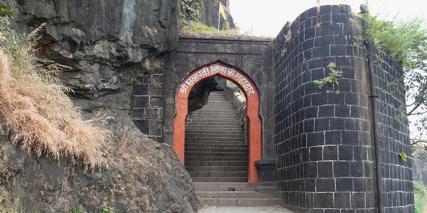 The majestic Sajjangad Fort is situated above a verdant slope.