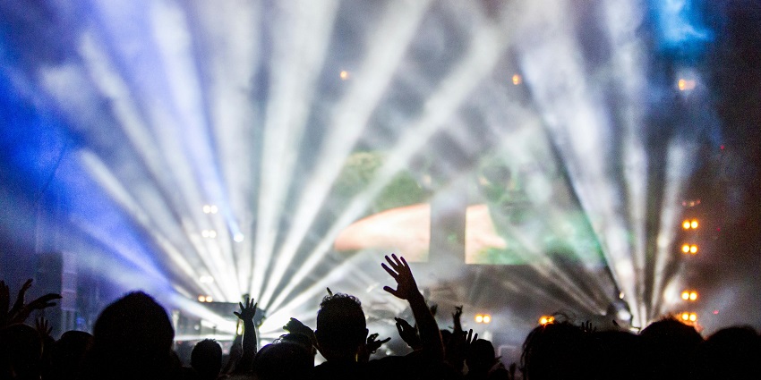 Image of people enjoying the DJ music in a club and dancing with their friends
