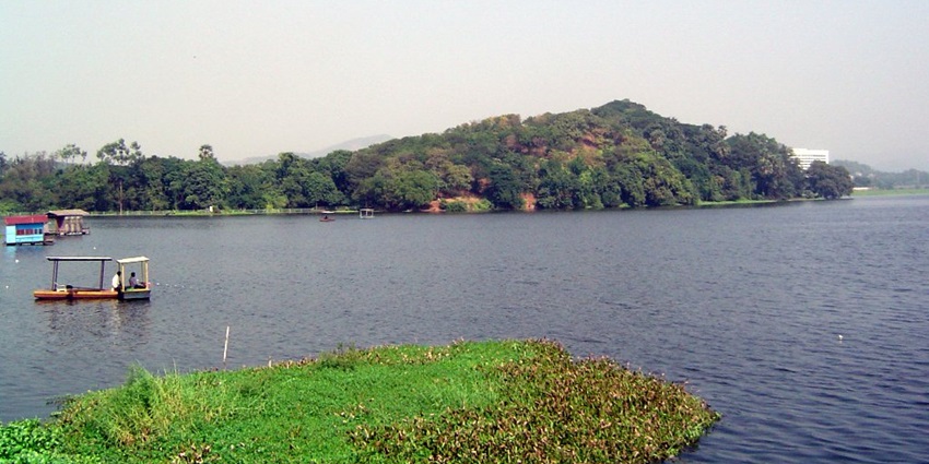 View of Powai Lake in Mumbai with surrounding greenery and buildings in the background