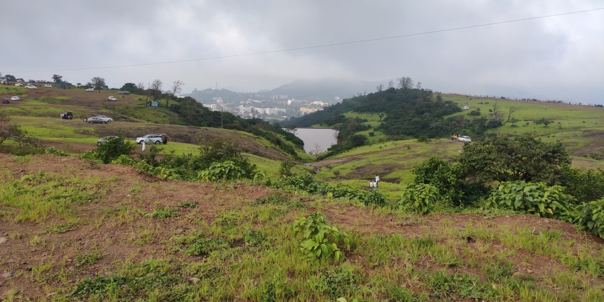 A picturesque view of the Saputara hills in Maharashtra with a small lake amidst the grassland