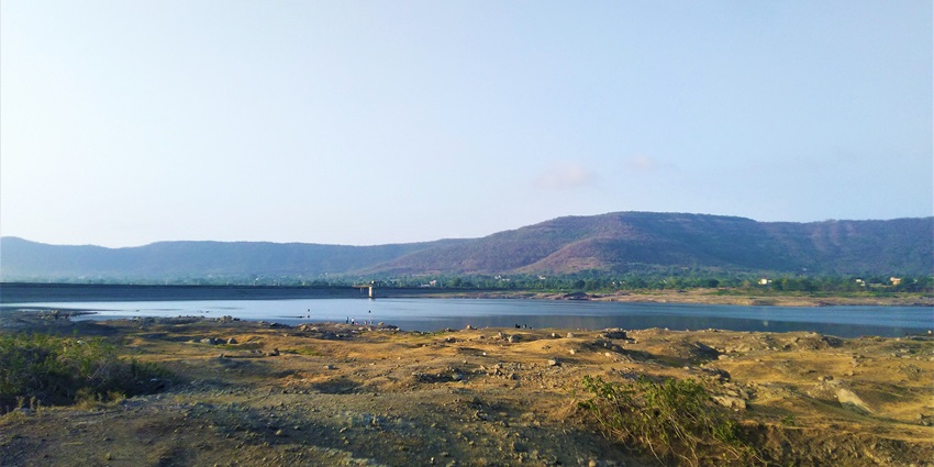 Kasarsai Dam from the adjoining area, showcasing its waters and surrounding greenery