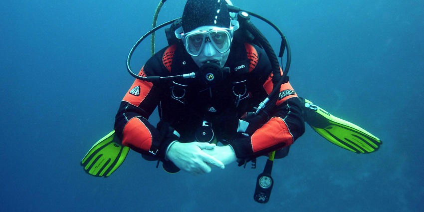 An image of scuba divers exploring vibrant marine life around the island's waters.
