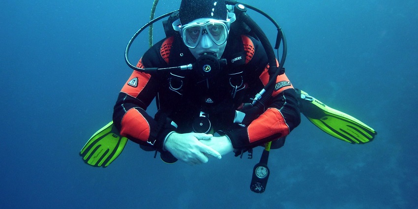 A picture of Scuba divers exploring the colourful underwater world, one of the adventure sports in Maharashtra.