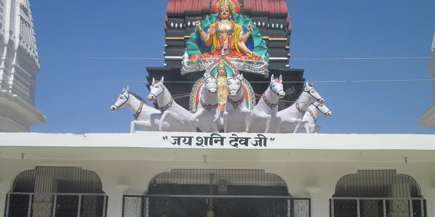 Front view of the Shani Devalaya, with an idol at the top of its entrance
