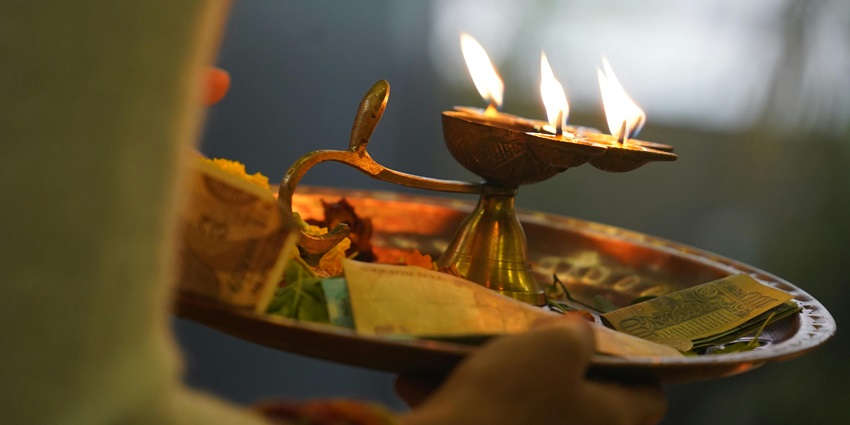 Image of a Person Holding a Metal Plate with Lighted Candles - Visit Shani Mandir in Yamunanagar