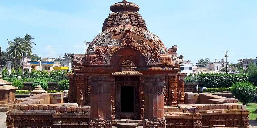 Image of a temple with ancient architecture during day time surrounded by lush greenery